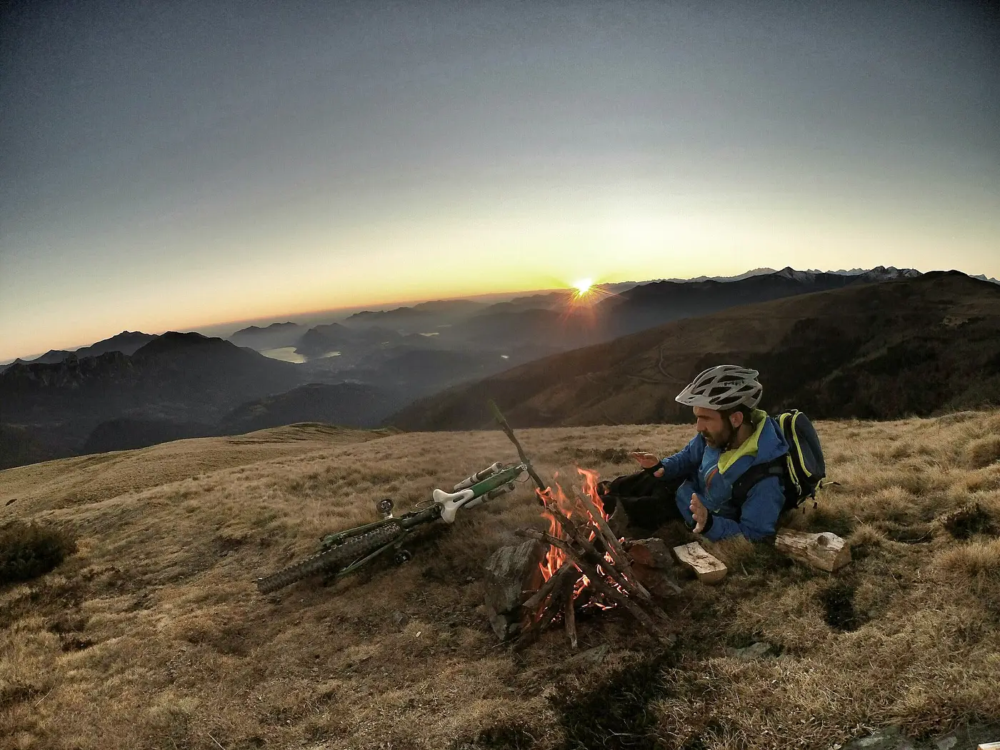 Cycliste au repos au sommet d'une colline au coucher du soleil